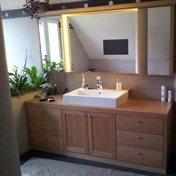 Modern classic bathroom with a wooden vanity with doors and drawers and a white ceramic sink