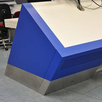 Custom-made furniture for an operating room in a technical facility, metal, straight plinth, blue sides, and white Corian top.