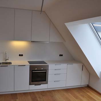 Einbauküche unter Dachschräge, Wand an Wand, schlichte, ganz in Weiß gehaltene Küche, Bosch-Backofen.