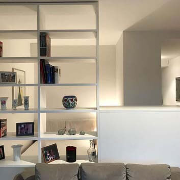 Raumteiler, Aufbewahrungslösung. Offenes Regal mit Büchern und Keramik in Weiß