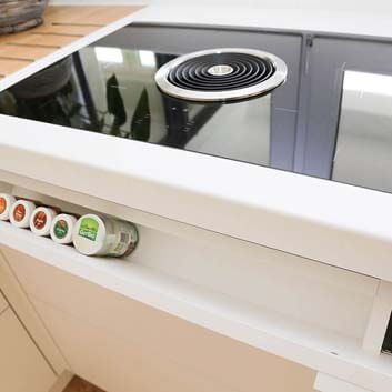 Kitchen with a special storage solution for spices and herbs, in the cabinet next to the Bora stove with extractor