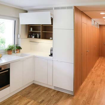 Contemporary interior, wood-paneled hallway, and L-shaped white kitchen